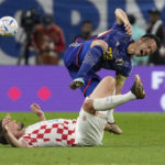 Croatia's Bruno Petkovic, bottom, challenges for the ball with Japan's Maya Yoshida during the World Cup round of 16 soccer match between Japan and Croatia at the Al Janoub Stadium in Al Wakrah, Qatar, Monday, Dec. 5, 2022. (AP Photo/Thanassis Stavrakis)