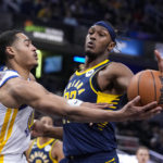
              Golden State Warriors guard Jordan Poole (3) tries to pass around Indiana Pacers center Myles Turner (33) during the first half of an NBA basketball game in Indianapolis, Wednesday, Dec. 14, 2022. (AP Photo/Michael Conroy)
            