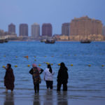 
              Women stand in the water at the Katara beach during the Soccer World Cup in Doha, Qatar, Thursday, Dec. 8, 2022. (AP Photo/Petr David Josek)
            