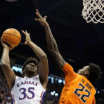 
              Kansas forward Zuby Ejiofor (35) shoots under pressure from Oklahoma State forward Kalib Boone (22) during the first half of an NCAA college basketball game Saturday, Dec. 31, 2022, in Lawrence, Kan. (AP Photo/Charlie Riedel)
            