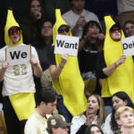 
              Fans dressed as bananas hold up a sequence of signs in hopes that Jackson State head football coach Deion Sanders will take the head coach opening at Colorado in the second half of an NCAA college basketball game as Colorado hosts Arizona State, Thursday, Dec. 1, 2022, in Boulder, Colo. (AP Photo/David Zalubowski)
            