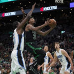 
              Boston Celtics guard Marcus Smart (36) drives to the basket ahead of Orlando Magic center Mo Bamba (11) during the first half of an NBA basketball game, Sunday, Dec. 18, 2022, in Boston. (AP Photo/Mary Schwalm)
            