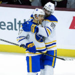 Buffalo Sabres Alex Tuch (89) gives Tyson Jost (17) a hug after his empty net goal against the Arizona Coyotes in the third period during an NHL hockey game, Saturday, Dec. 17, 2022, in Tempe, Ariz. Buffalo Sabres won 5-2 over the Arizona Coyotes. (AP Photo/Darryl Webb)