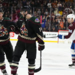 Arizona Coyotes defenseman Shayne Gostisbehere, middle, celebrates his goal against the Colorado Avalanche with Coyotes left wing Nick Ritchie as Avalanche right wing Mikko Rantanen (96) skates away during the first period of an NHL hockey game in Tempe, Ariz., Tuesday, Dec. 27, 2022. (AP Photo/Ross D. Franklin)