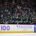 Vancouver Canucks celebrate on the bench after Bo Horvat scored against the Arizona Coyotes during overtime in an NHL hockey game Saturday, Dec. 3, 2022, in Vancouver, British Columbia. (Darryl Dyck/The Canadian Press via AP)