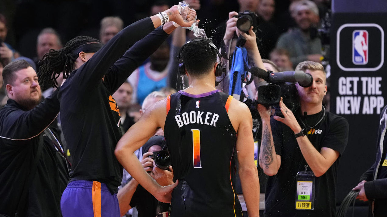Phoenix Suns guard Devin Booker (1) has water poured on his head by teammate Damion Lee after an NB...