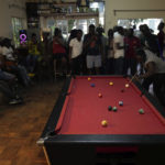 
              People play pool in a bar on the outskirts of Harare, Zimbabwe, Saturday, Nov. 19, 2022. Previously a minority and elite sport in Zimbabwe, the game has increased in popularity over the years, first as a pastime and now as a survival mode for many in a country where employment is hard to come by. (AP Photo/Tsvangirayi Mukwazhi)
            