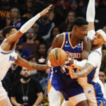 Washington Wizards' Monte Morris, left, and Daniel Gafford, right, double team Phoenix Suns' Deandre Ayton, middle, during the first half of an NBA basketball game in Phoenix, Tuesday, Dec. 20, 2022. (AP Photo/Darryl Webb)