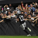 Las Vegas Raiders wide receiver Davante Adams (17) celebrates his touchdown reception as he runs past fans during the second half of an NFL football game against the Los Angeles Chargers, Sunday, Dec. 4, 2022, in Las Vegas. (AP Photo/David Becker)