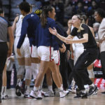 
              Connecticut's Paige Bueckers, right, runs on the court to talk to an office during a timeout in the first half of an NCAA college basketball game against Florida State, Sunday, Dec. 18, 2022, in Uncasville, Conn. (AP Photo/Jessica Hill)
            