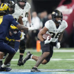 Purdue running back Dylan Downing runs with the ball past Michigan defensive back Makari Paige (7) during the first half of the Big Ten championship NCAA college football game, Saturday, Dec. 3, 2022, in Indianapolis. (AP Photo/AJ Mast)