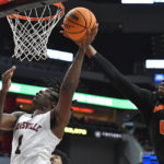 
              Miami forward Anthony Walker (1) attempts to block the shot of Louisville guard Mike James (1) during the second half of an NCAA college basketball game in Louisville, Ky., Sunday, Dec. 4, 2022. Miami won 80-53. (AP Photo/Timothy D. Easley)
            