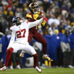Washington Commanders wide receiver Jahan Dotson (1) catches a pass over New York Giants cornerback Jason Pinnock (27) during the second half of an NFL football game, Sunday, Dec. 18, 2022, in Landover, Md. (AP Photo/Nick Wass)