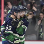 Vancouver Canucks' Bo Horvat, left, and Elias Pettersson celebrate Horvat's goal against the Arizona Coyotes during the first period of an NHL hockey game Saturday, Dec. 3, 2022, in Vancouver, British Columbia. (Darryl Dyck/The Canadian Press via AP)
