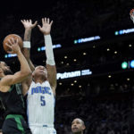 
              Boston Celtics guard Derrick White shoots against the defense from Orlando Magic forward Paolo Banchero (5) during the first half of an NBA basketball game, Sunday, Dec. 18, 2022, in Boston. (AP Photo/Mary Schwalm)
            