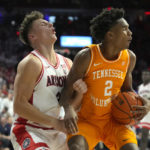 Arizona guard Pelle Larsson draws the offensive foul on Tennessee forward Julian Phillips (2) during the first half of an NCAA college basketball game, Saturday, Dec. 17, 2022, in Tucson, Ariz. (AP Photo/Rick Scuteri)