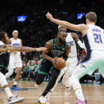 Boston Celtics guard Jaylen Brown, center, drives to the basket past Orlando Magic defenders during the first half of an NBA basketball game, Sunday, Dec. 18, 2022, in Boston. (AP Photo/Mary Schwalm)