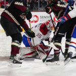 Montreal Canadiens' goalie Sam Montembeault (35) covers the puck between two Arizona Coyotes players in the first period during an NHL hockey game, Monday, Dec. 19, 2022, in Tempe, Ariz. (AP Photo/Darryl Webb)