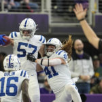 Indianapolis Colts linebacker JoJo Domann (57) celebrates with teammates Ashton Dulin (16) and Grant Stuard (41) after returning a blocked punt for a touchdown during the first half of an NFL football game against the Minnesota Vikings, Saturday, Dec. 17, 2022, in Minneapolis. (AP Photo/Abbie Parr)
