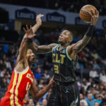 Charlotte Hornets guard Terry Rozier, right, drives into the lane against Atlanta Hawks forward De'Andre Hunter, left, during the first half of an NBA basketball game Friday, Dec. 16, 2022, in Charlotte, N.C. (AP Photo/Rusty Jones)