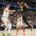 
              Utah Jazz guard Ochai Agbaji, front right, loses control of the ball while driving to the basket as Denver Nuggets center Nikola Jokic, front left, and guard Bones Hyland (3) defend in the second half of an NBA basketball game Saturday, Dec. 10, 2022, in Denver. (AP Photo/David Zalubowski)
            