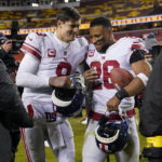 New York Giants quarterback Daniel Jones (8) and running back Saquon Barkley (26) walk off the field after a 20-12 victory over the Washington Commanders, Sunday, Dec. 18, 2022, in Landover, Md. (AP Photo/Susan Walsh)