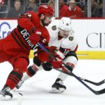 
              Detroit Red Wings center Dylan Larkin (71) and Ottawa Senators left wing Tim Stützle (18) reach for the puck during the third period of an NHL hockey game Saturday, Dec. 31, 2022, in Detroit. (AP Photo/Duane Burleson)
            
