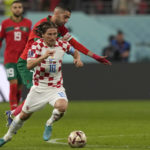 
              Croatia's Luka Modric, front, duels for the ball with Morocco's Hakim Ziyech during the World Cup third-place playoff soccer match between Croatia and Morocco at Khalifa International Stadium in Doha, Qatar, Saturday, Dec. 17, 2022. (AP Photo/Frank Augstein)
            