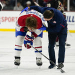 Montreal Canadiens' Christian Dvorak (28) is helped off the ice after getting hit in the face by the puck in the first period during an NHL hockey game against the Arizona Coyotes, Monday, Dec. 19, 2022, in Tempe, Ariz. (AP Photo/Darryl Webb)