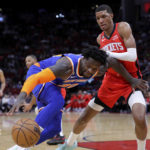 
              New York Knicks forward Julius Randle, left, loses control of the ball as he tries to drive around Houston Rockets forward Jabari Smith Jr., right, during the first half of an NBA basketball game Saturday, Dec. 31, 2022, in Houston. (AP Photo/Michael Wyke)
            