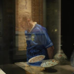 A man wearing a Brazil soccer shirt walks past a bowl from Iran at the Museum of Islamic Art in Doha, Qatar, Tuesday, Nov. 22, 2022. (AP Photo/Christophe Ena)