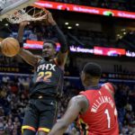 Phoenix Suns center Deandre Ayton (22) dunks against New Orleans Pelicans forward Zion Williamson (1) in the first half of an NBA basketball game in New Orleans, Friday, Dec. 9, 2022. (AP Photo/Matthew Hinton)