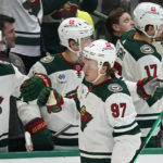 Minnesota Wild left wing Kirill Kaprizov (97) celebrates with teammates on the bench after his goal during the first period of an NHL hockey game against the Dallas Stars in Dallas, Sunday, Dec. 4, 2022. (AP Photo/LM Otero)