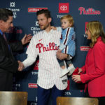 
              Newly acquired Philadelphia Phillies shortstop Trea Turner, center, greets manager Rob Thomson, left, after his introductory news conference, Thursday, Dec. 8, 2022, in Philadelphia. At right is Turner's wife, Kristen, and son, Beckham. (AP Photo/Matt Slocum)
            