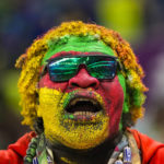 A Cameroon fan cheers up at the stand prior the World Cup group G soccer match between Cameroon and Brazil, at the Lusail Stadium in Lusail, Qatar, Friday, Dec. 2, 2022. (AP Photo/Andre Penner)