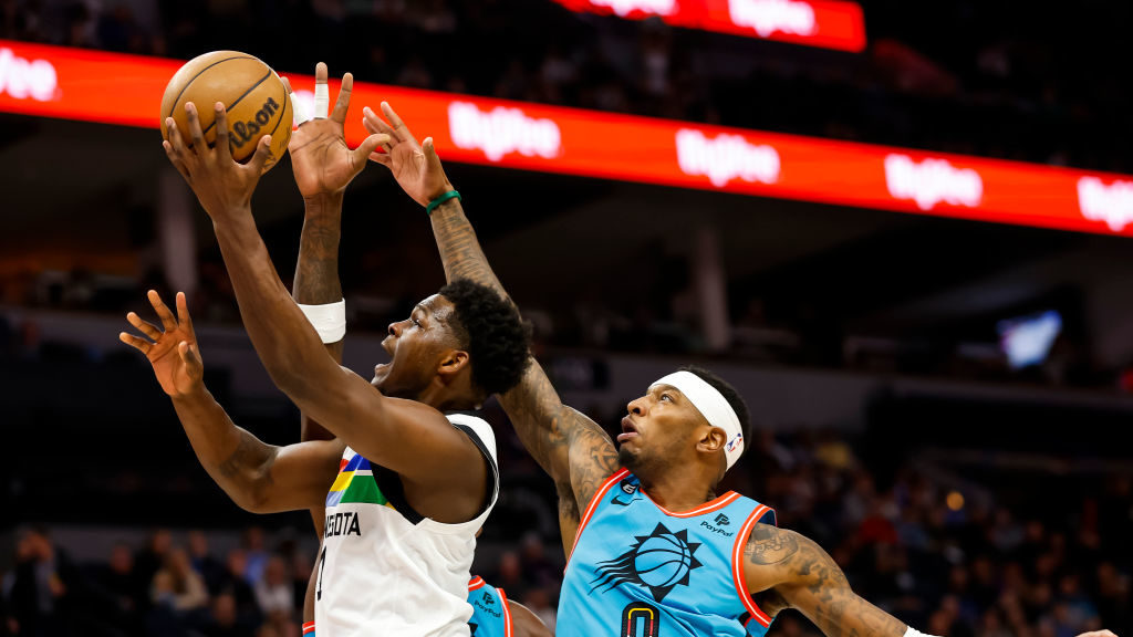 Anthony Edwards #1 of the Minnesota Timberwolves goes up for a shot past Torrey Craig #0 of the Pho...