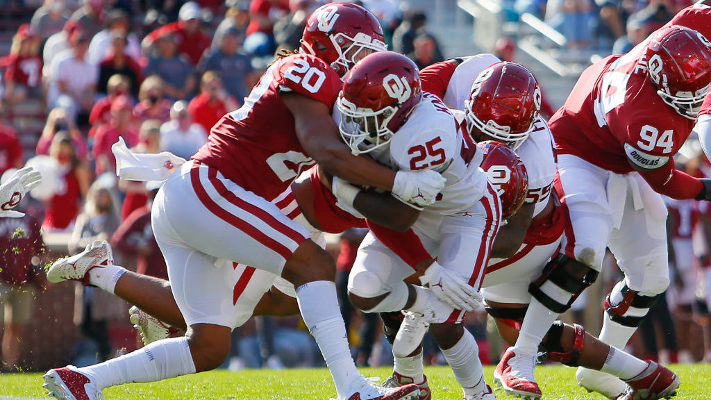 Running back Jaden Knowles #25 of the Oklahoma Sooners breaks through the tackle of outside linebac...