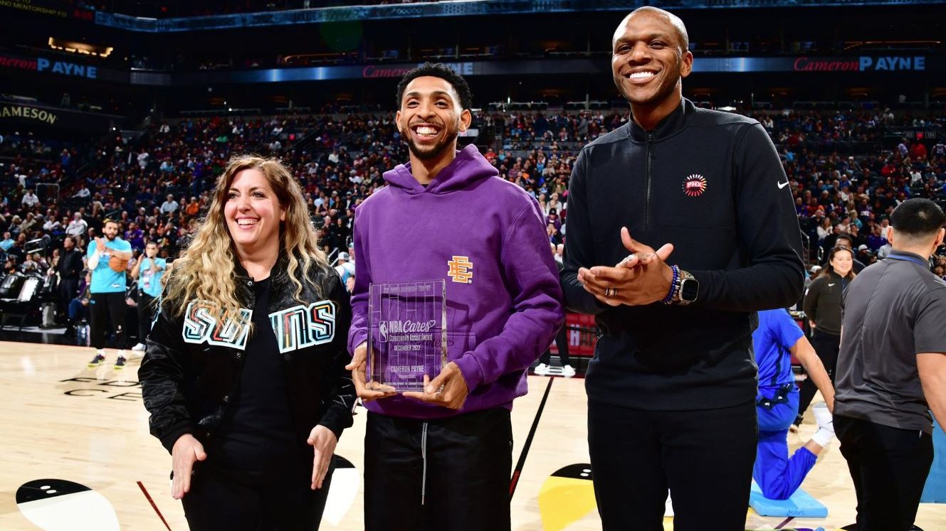 Phoenix Suns point guard Cam Payne (center) receives the 2022 December NBA Cares Community Assist A...