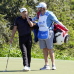 
              Collin Morikawa stands with his caddie on the 18th green during the final round of the Tournament of Champions golf event, Sunday, Jan. 8, 2023, at Kapalua Plantation Course in Kapalua, Hawaii. (AP Photo/Matt York)
            