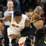 Phoenix Suns guard Chris Paul, right, fouls Miami Heat guard Victor Oladipo (4) during the first half of an NBA basketball game in Phoenix, Friday, Jan. 6, 2023. (AP Photo/Ross D. Franklin)