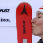 United States' Mikaela Shiffrin kisses her skis as she celebrates on the podium after winning an alpine ski, women's World Cup giant slalom, in Kronplatz, Italy, Tuesday, Jan. 24, 2023. Shiffrin won a record 83rd World Cup race Tuesday. (AP Photo/Alessandro Trovati)