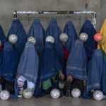 
              An Afghan women's soccer team poses for a photo in Kabul, Afghanistan, Thursday, Sept. 22, 2022. The ruling Taliban have banned women from sports as well as barring them from most schooling and many realms of work. A number of women posed for an AP photographer for portraits with the equipment of the sports they loved. Though they do not necessarily wear the burqa in regular life, they chose to hide their identities with their burqas because they fear Taliban reprisals and because some of them continue to practice their sports in secret. (AP Photo/Ebrahim Noroozi)
            