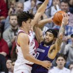 
              Indiana guard Trey Galloway (32) defends against Northwestern guard Boo Buie (0) during the second half of an NCAA college basketball game, Sunday, Jan. 8, 2023, in Bloomington, Ind. (AP Photo/Doug McSchooler)
            