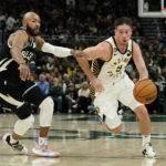 Indiana Pacers' T.J. McConnell drives to the basket against Milwaukee Bucks' Jevon Carter during the first half of an NBA basketball game, Monday, Jan. 16, 2023, in Milwaukee. (AP Photo/Aaron Gash)