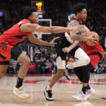 
              Portland Trail Blazers guard Anfernee Simons, front right, dribbles as Toronto Raptors forward Scottie Barnes, left, and guard Fred VanVleet (23) defend during first-half NBA basketball game action in Toronto, Sunday, Jan. 8, 2023. (Frank Gunn/The Canadian Press via AP)
            