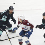 
              Seattle Kraken defenseman Jamie Oleksiak (24) and Colorado Avalanche center Evan Rodrigues (9) look up for the puck during the first period of an NHL hockey game Saturday, Jan. 21, 2023, in Seattle. (AP Photo/Lindsey Wasson)
            
