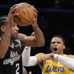 
              Los Angeles Clippers forward Kawhi Leonard, center, tries to pass while under pressure from Los Angeles Lakers forward Wenyen Gabriel, left, and guard Russell Westbrook during the first half of an NBA basketball game Tuesday, Jan. 24, 2023, in Los Angeles. (AP Photo/Mark J. Terrill)
            