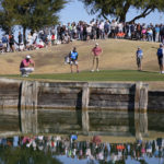 Jon Rahm, left, measures his putt as Davis Thompson, center, watches on the fifth hole during the final round of the American Express golf tournament on the Pete Dye Stadium Course at PGA West Sunday, Jan. 22, 2023, in La Quinta, Calif. (AP Photo/Mark J. Terrill)
