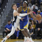 
              Golden State Warriors forward Kevon Looney, right, looks to pass the ball while defended by Orlando Magic center Moritz Wagner during the first half of an NBA basketball game in San Francisco, Saturday, Jan. 7, 2023. (AP Photo/Jeff Chiu)
            