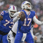 Buffalo Bills quarterback Josh Allen (17) takes a hit from Cincinnati Bengals defensive end Trey Hendrickson (91) during the second quarter of an NFL division round football game, Sunday, Jan. 22, 2023, in Orchard Park, N.Y. (AP Photo/Adrian Kraus)